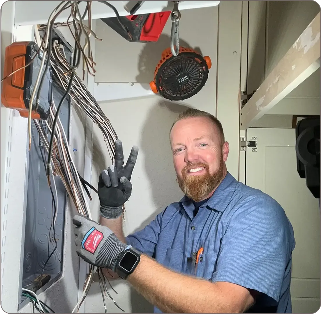 Eddie Burton is fixing tangled electrical cables while flashing the peace sign.